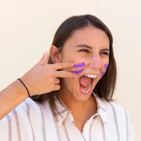 female using purple paint on her face