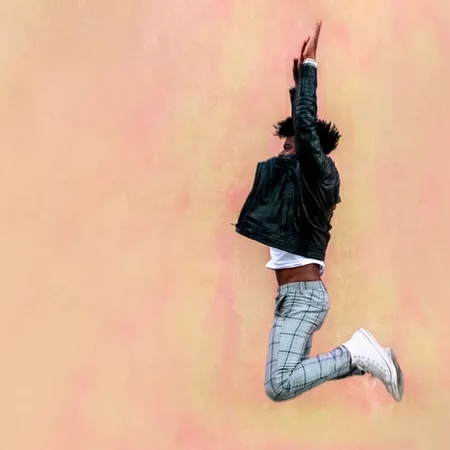 Male person jumping up kicking his legs back in the air