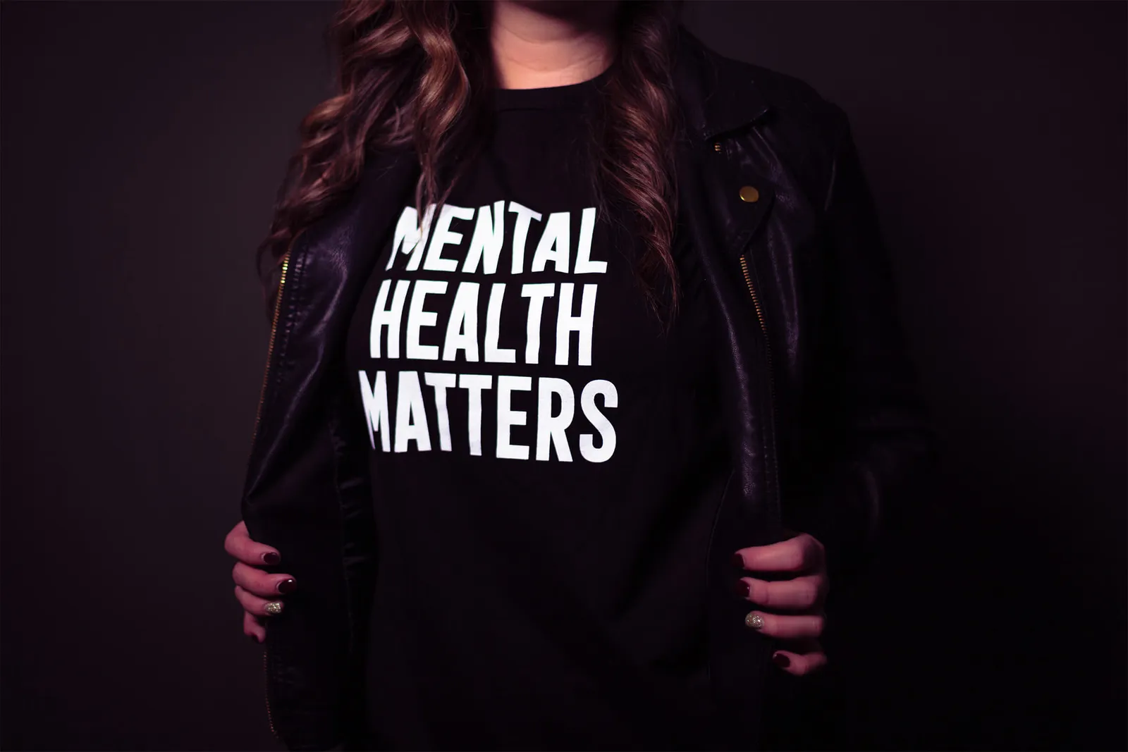 female wearing a black shirt reads mental health matters