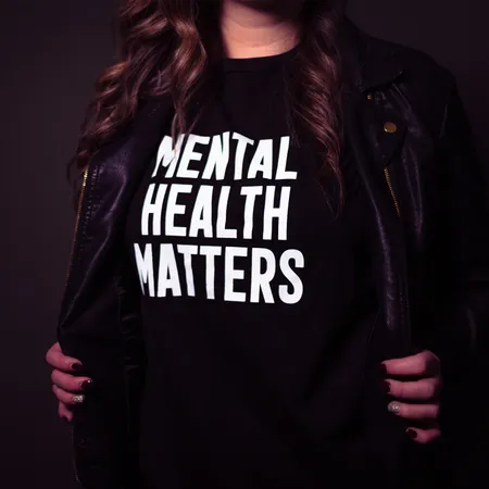 female wearing a black shirt reads mental health matters