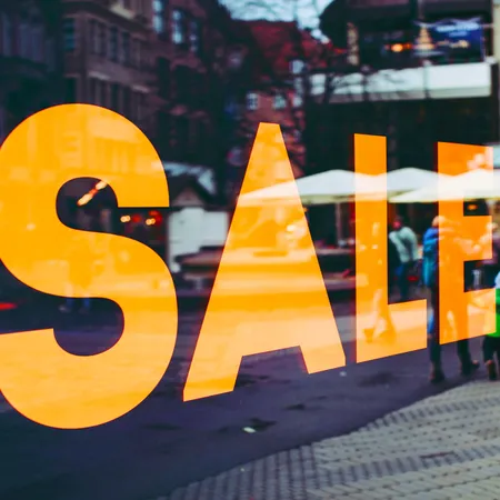 big yelllow sale sign in a shop window