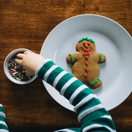 child decorating a gingerbread man