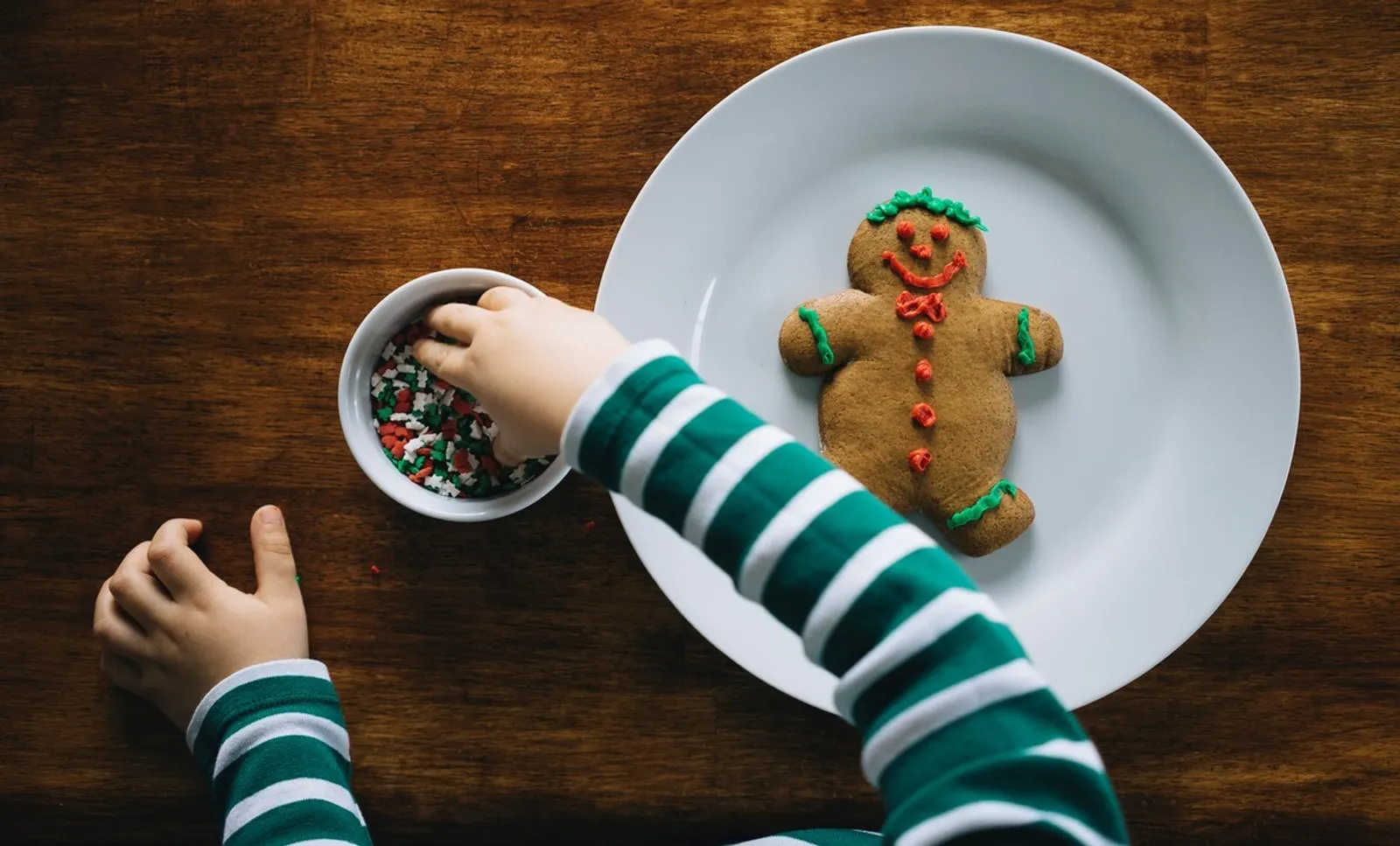 child decorating a gingerbread man