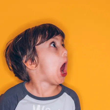 boy shouting on a yellow background