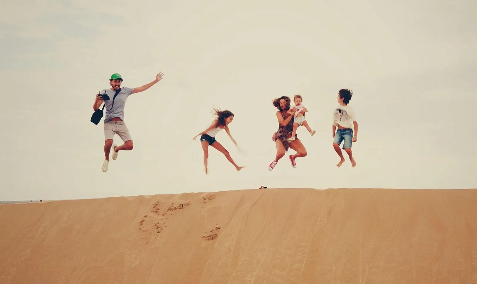 family jump with jumps in the sand dune