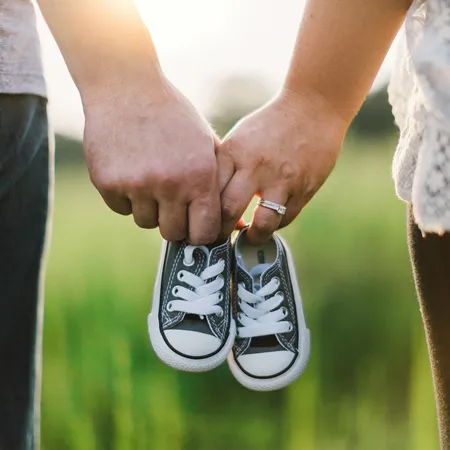 male and female holding childrens shoes