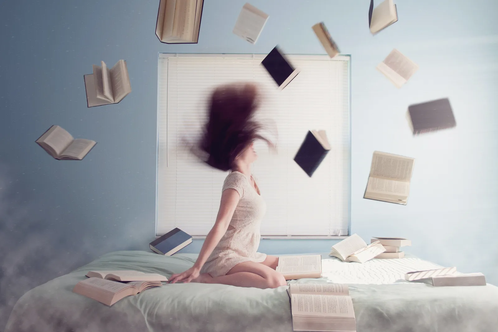 Girl throwing hair back surrounded by books