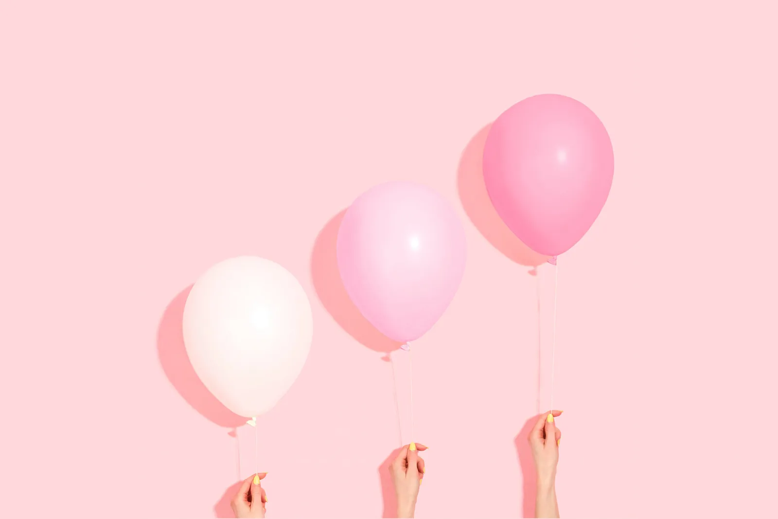 three balloons on a pink background with shades of pink