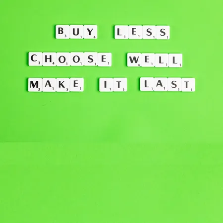 green back ground with scrabble pieces spelling out buy less choose well