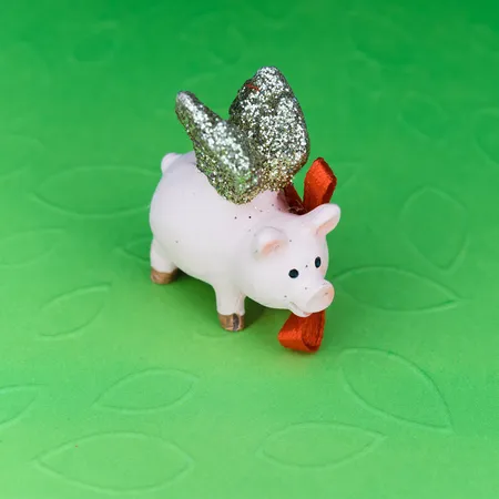 piggy bank with wings and a red bow