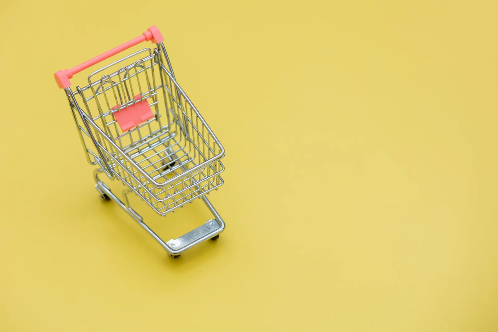 toy shopping trolley on yellow background