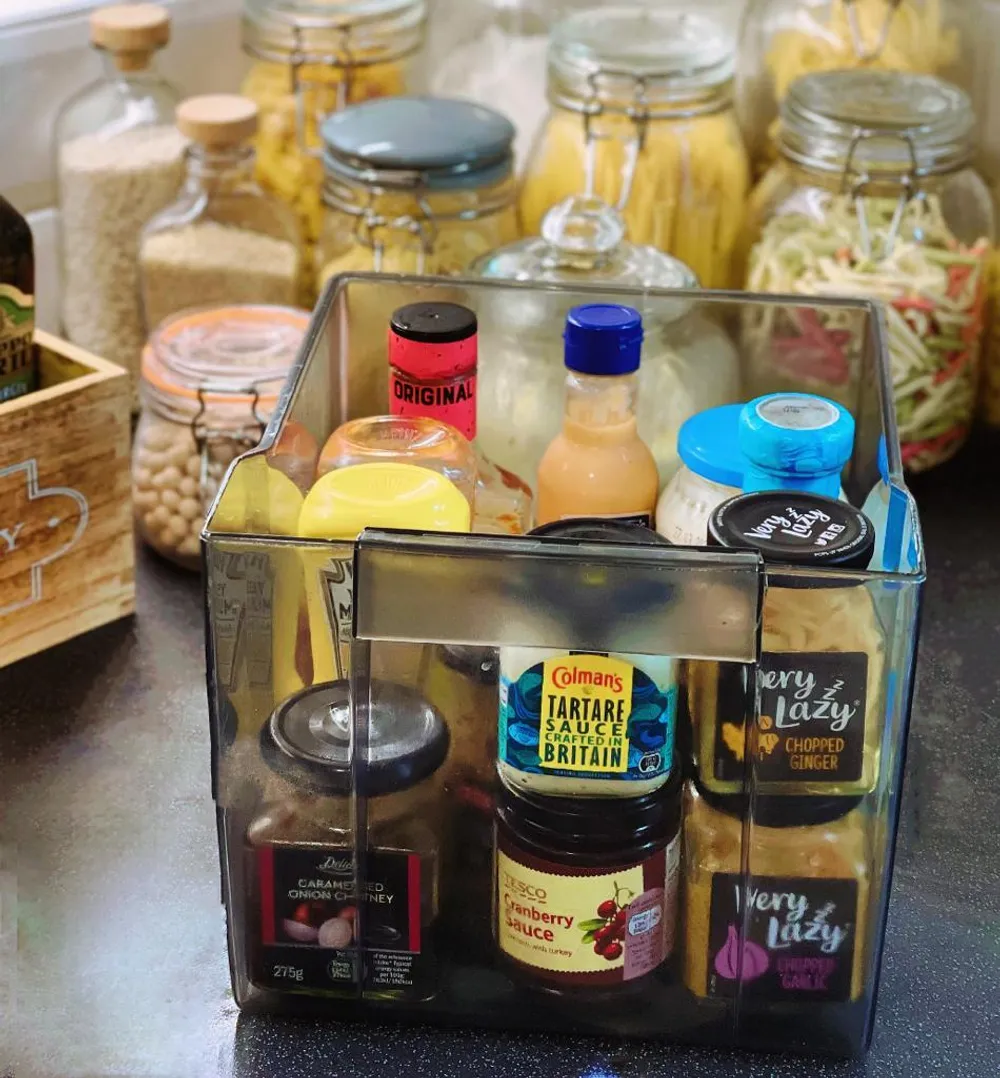 A fridge drawer with various condiments and sauces inside